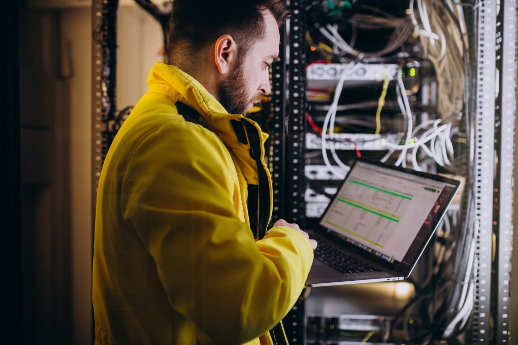 Cloud storage solutions technician managing secure business servers with a laptop